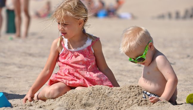 Meisje speelt met zand op het strand van Katwijk Zuid-Holland in de zomer